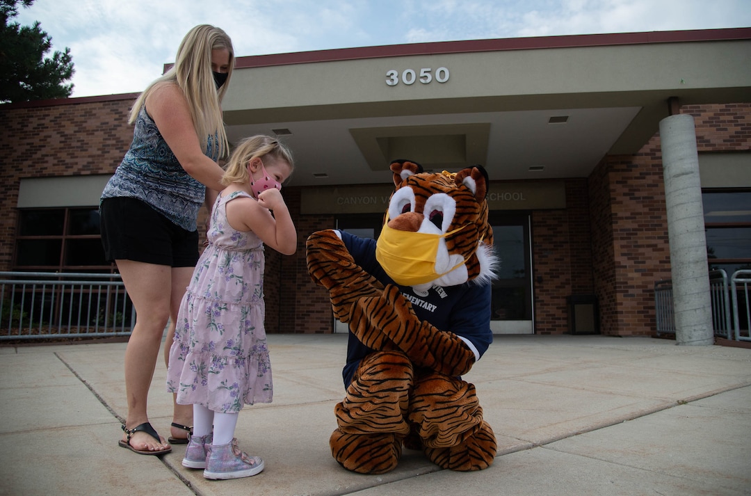 (Francisco Kjolseth  |  The Salt Lake Tribune)  Home of the Cubs, Canyon View Elementary school mascot Bennie, played by PTA president Emily Weigel gets an elbow bump from Maya Brown, 4, who will attend the school next year as she is joined by her mother on the first day of classes for the Canyons School District on Monday, August 24, 2020.