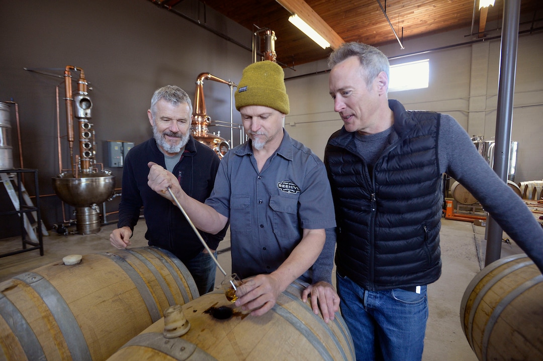 (Al Hartmann  |  The Salt Lake Tribune) 	
Matt Aller, left, Chris Barlow, and Erik Ostling, co-owners of Beehive Distilling check on the Barrel Reserve Gin at their new Salt Lake City location at 2245 S. West Temple.  The new 450-gallon copper still in the background will allow the team to increase production.
