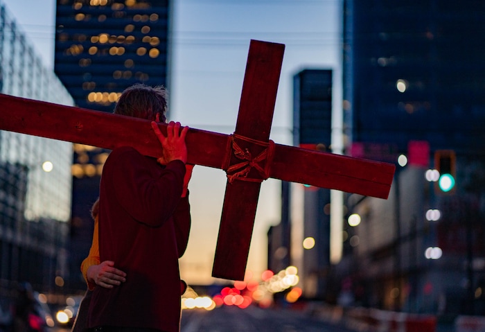 (Francisco Kjolseth | The Salt Lake Tribune) Maurice Mede and his wife Audrey takes a turn carrying the cross as mask wearing Utah Christians walk the streets of Salt Lake City beginning at Cathedral of the Madeleine on Good Friday, to symbolically mark Jesus' carrying the cross to his crucifixion, April 2, 2021.