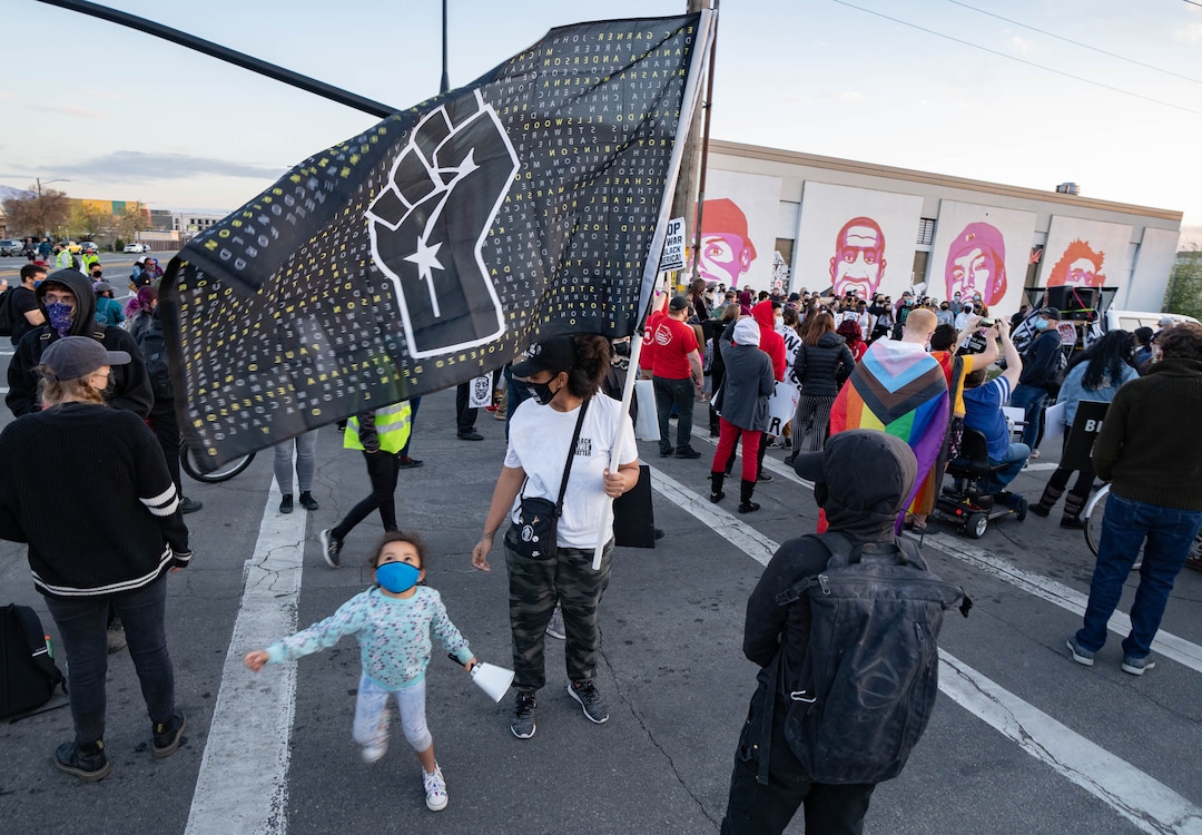 (Francisco Kjolseth  | The Salt Lake Tribune) Rae Duckworth hold a flag as she joins others at the murals of people killed by police, including Rae’s cousin, in Salt Lake City on Tuesday, April 20, 2021, following the guilty verdict on all three counts in the murder trial of former Minneapolis police Officer Derek Chauvin in the death of George Floyd.