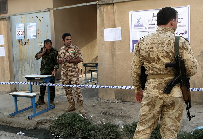 Kurdish security services stand guard outside polling center shortly before opening for the referendum on independence from Iraq in Irbil, Iraq, Monday, Sept. 25, 2017. (AP Photo/Khalid Mohammed)