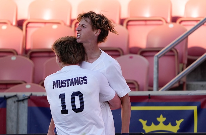 (Francisco Kjolseth | The Salt Lake Tribune) Herriman's Trevor Walk (7) is embraced by Herriman's Grant Taylor (10) after scoring the game winning goal over Davis with only two seconds left on the clock during the 6A State Soccer Championship title game at Rio Tinto Stadium, Wednesday, May 25, 2022. Herriman defeated Davis 1-0.