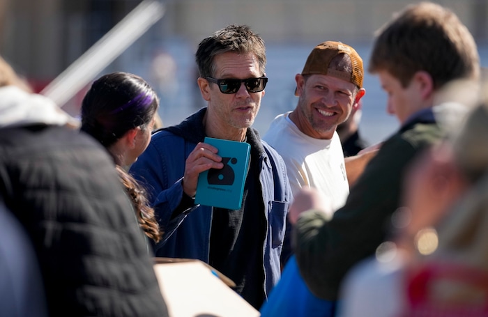 (Bethany Baker | The Salt Lake Tribune) Kevin Bacon packs resource kits with students and volunteers for his nonprofit SixDegrees at a charity event to commemorate the 40th anniversary of the movie "Footloose" on the football field of Payson High School in Payson on Saturday, April 20, 2024.