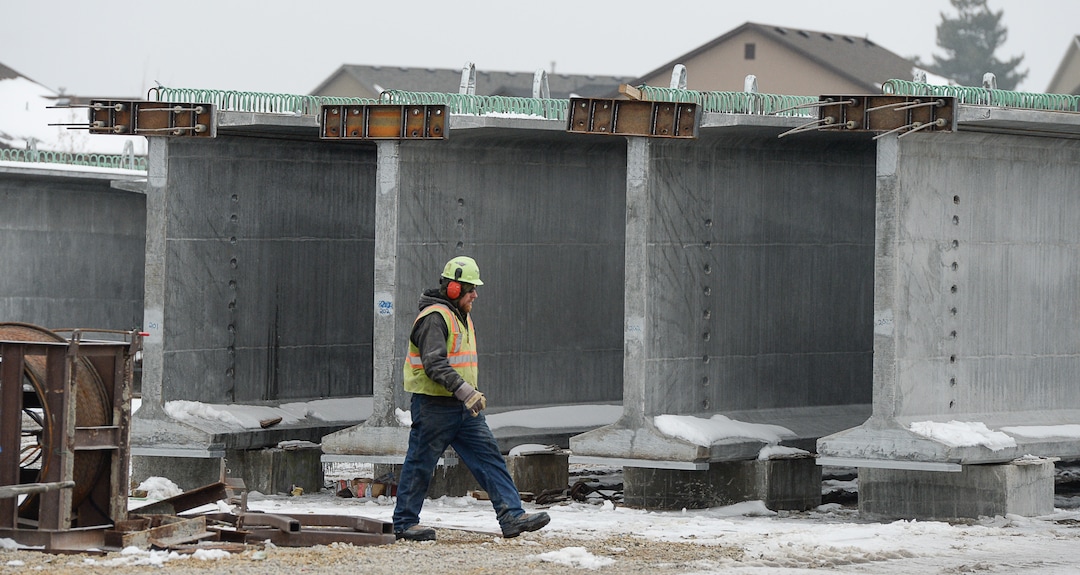 (Francisco Kjolseth  |  The Salt Lake Tribune)  A crew member walks amongst the giants as UDOT gets ready to place some of the world's largest-ever bridge beams, and the largest in Utah state history, with a span of 203 ft long and just over 8 ft tall. Crews began to load the pieces following manufacturing at Forterra Structural Precast in Kearns on Tuesday, Dec. 11, 2018. A total of six beams will be installed in the technology corridor in Lehi later this week.