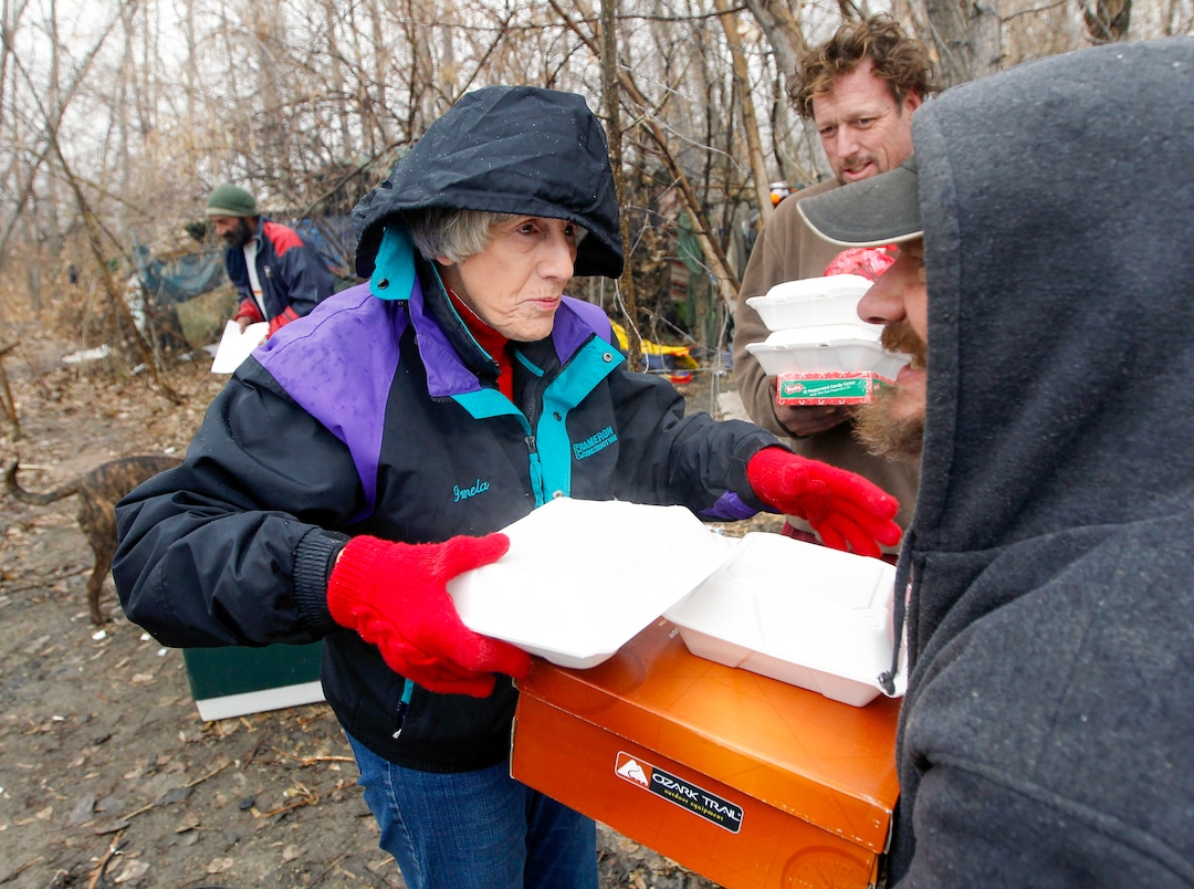 (Al Hartmann | The Salt Lake Tribune)
Pamela Atkinson delivers a hot meal, boots and a warm coat to a homeless man who lives in a camp along the Jordan River in 2012.