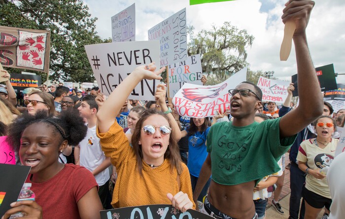 Therese Gachnauer, center, a 18 year old senior from Chiles High School and Kwane Gatlin, right, a 19 year old senior from Lincoln High School, both in Tallahassee, join fellow students protesting gun violence on the steps of the old Florida Capitol in Tallahassee, Fla., Wednesday, Feb. 21, 2018.    Students at schools across Broward and Miami-Dade counties in South Florida planned short walkouts Wednesday, the one week anniversary of the deadly shooting at Marjory Stoneman Douglas High School. (AP Photo/Mark Wallheiser)