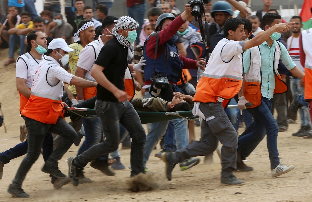 Palestinian medics evacuate a wounded youth during a protest at the Gaza Strip's border with Israel, east of Khan Younis, Friday, May 4, 2018. (AP Photo/Adel Hana)