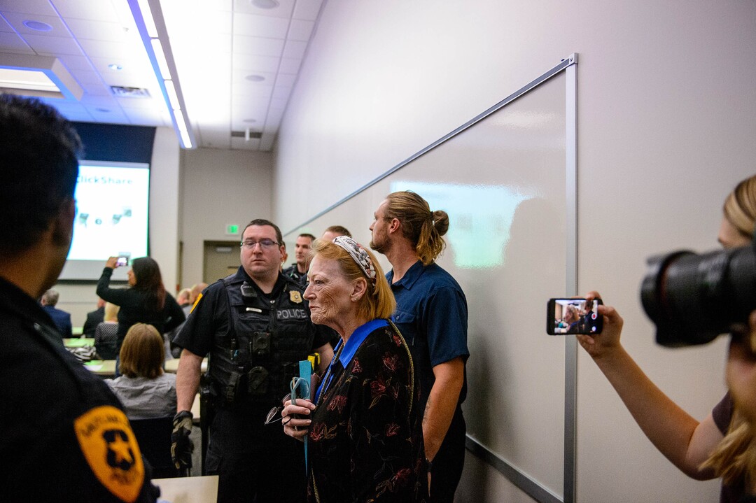 (Trent Nelson  |  The Salt Lake Tribune)  
Ethan Peterson argues with police who are removing him from a meeting of an inland port satellite working group (which was quickly canceled), held at a police precinct in Salt Lake City on Wednesday, Aug. 14, 2019. At front is Jill Merritt.