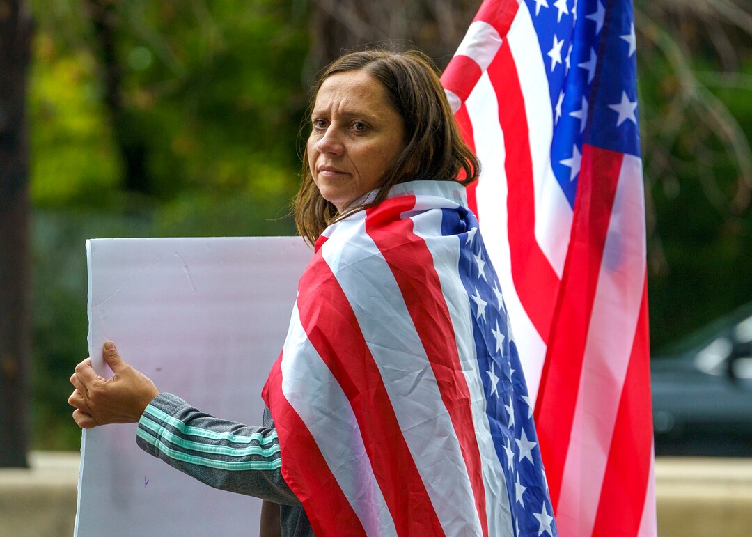 (Leah Hogsten | The Salt Lake Tribune) Protesters waving American flags and holding signs decrying mask and vaccine mandates gathered along the curb of 700 East in Liberty Park Saturday, making Salt Lake City one of dozens of cities around the world protesting public health-related restrictions, Sept. 18, 2021.