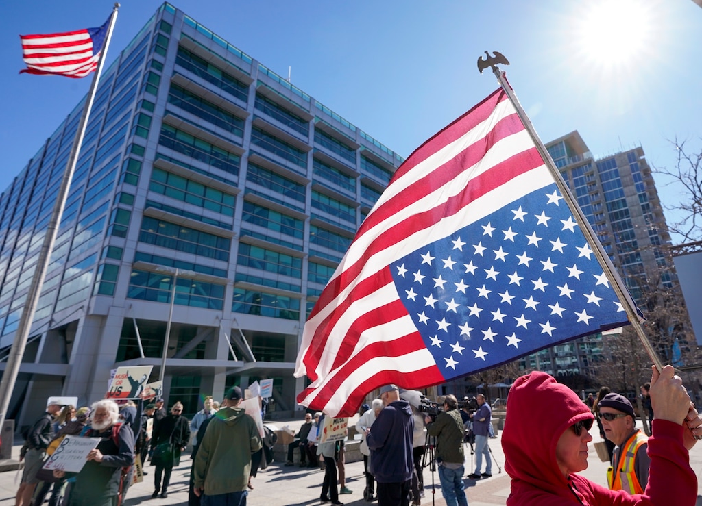 (Chris Samuels | The Salt Lake Tribune) Angie Keaton of North Salt Lake carries an upside down American flag during a protest against Elon Musk and the Trump administration outside the Wallace F. Bennett Federal Building in Salt Lake City, Wednesday, Feb. 26, 2025.