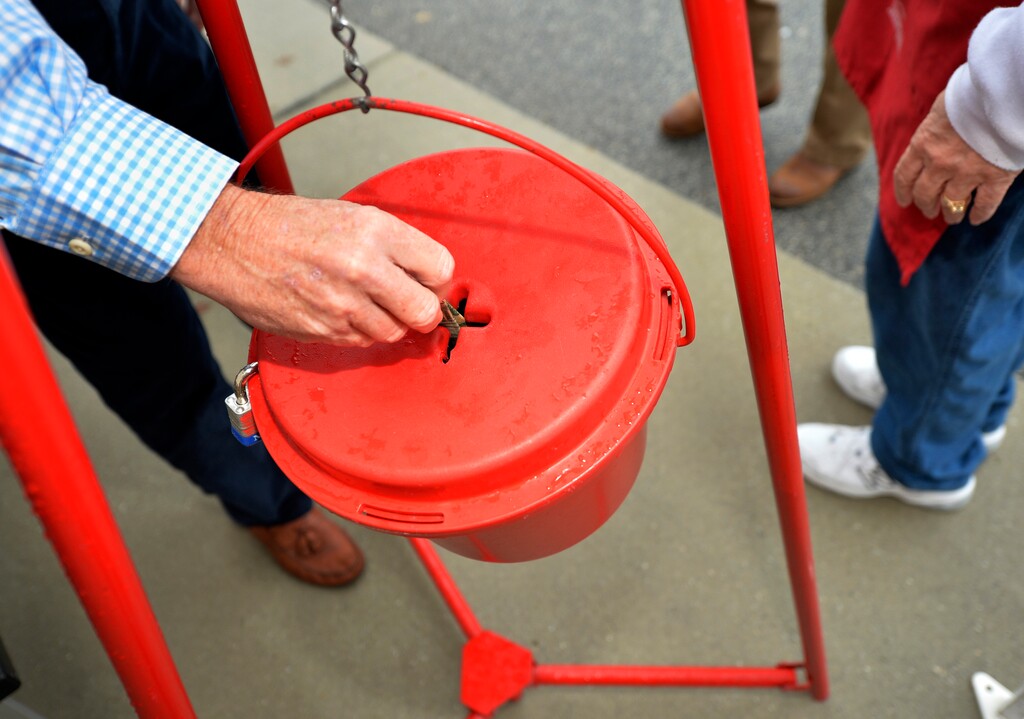 (Michael Holahan | The Augusta Chronicle via The Associated Press) In this Nov. 9, 2018, money gets dropped into the kettle during the Annual Salvation Army Red Kettle and Angel Tree Kick Off outside the Hobby Lobby store in Augusta, Ga.