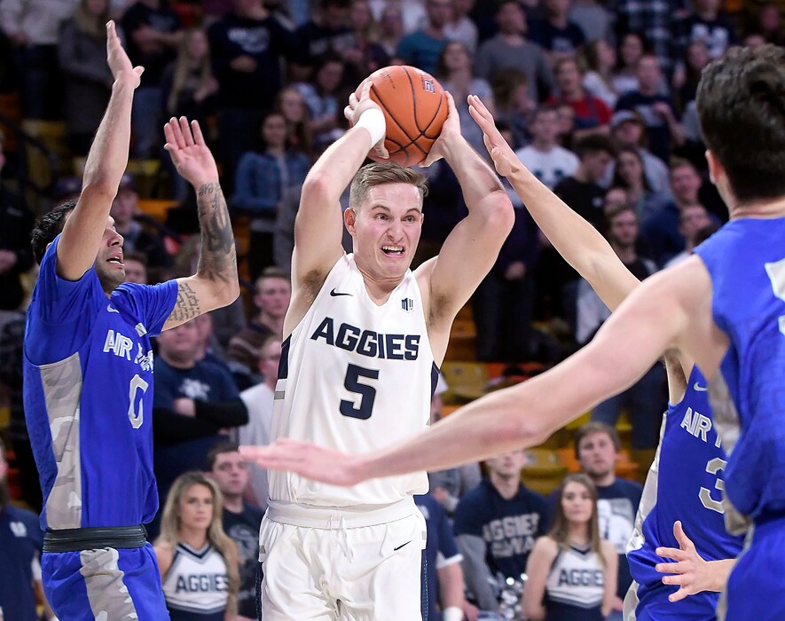 Utah State guard Sam Merrill (5) passes the ball as Air Force guard Caleb Morris (0) defends during an NCAA college basketball game Saturday, Jan. 5, 2019, in Logan, Utah. (Eli Lucero/The Herald Journal via AP)