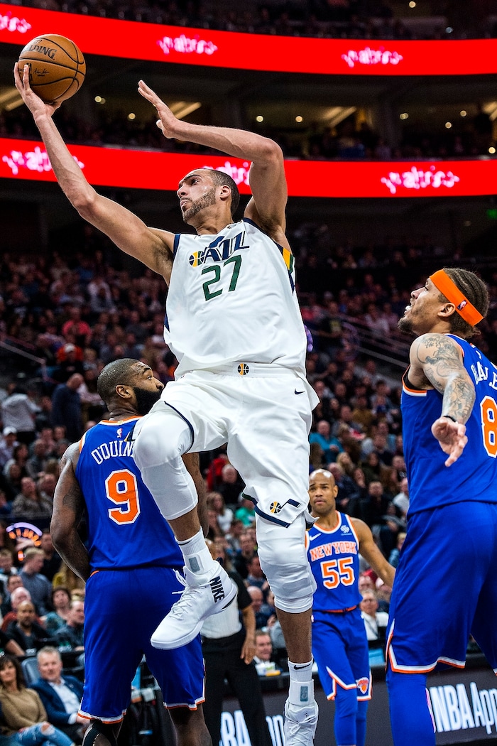 (Chris Detrick  |  The Salt Lake Tribune)  Utah Jazz center Rudy Gobert (27) shoots past New York Knicks center Kyle O'Quinn (9) and New York Knicks forward Michael Beasley (8) during the game at Vivint Smart Home Arena Friday, January 19, 2018.  