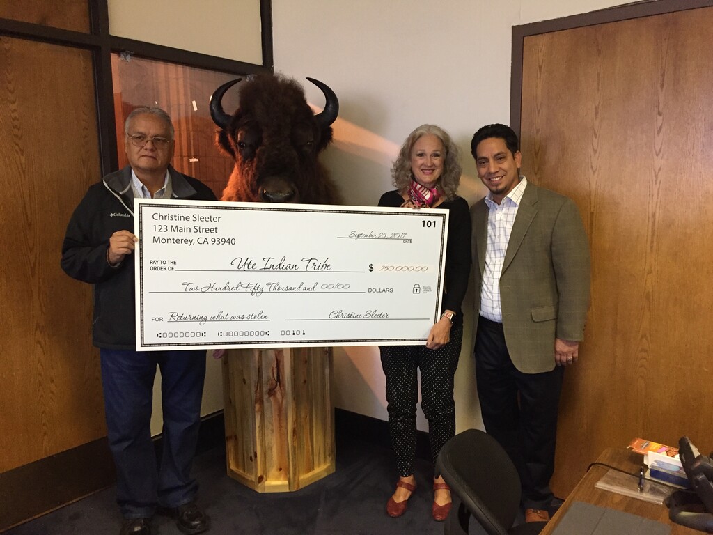 (Photo courtesy of Ute Indian Tribe Political Action Committee) From left, Ronald Wopsock, a member of the Ute Indian Tribe Business Committee, accepts a $250,000 check from Christine Sleeter (middle). Ute PAC Director Robert Lucero stands to the right.