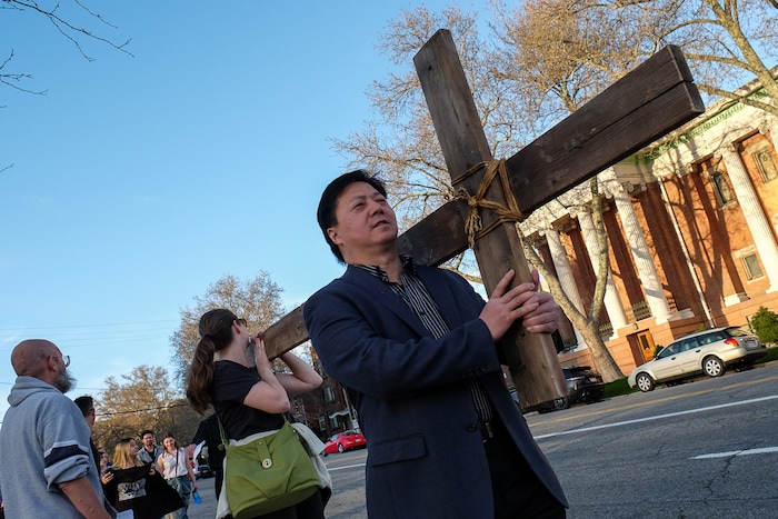 (Francisco Kjolseth  |  The Salt Lake Tribune)  Yichen Lee joins other christians as they march through streets of Salt Lake City on Good Friday to symbolically mark Jesus' carrying the cross to his crucifixion beginning at Cathedral of the Madeleine.