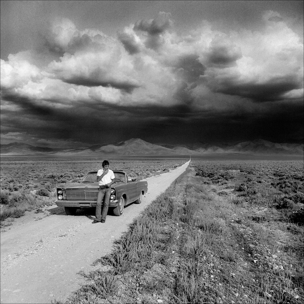 Bruce Springsteen stops his car underneath storm clouds near Unionville, Nev., on Aug. 20, 1977. Copyright Eric Meola 2007.