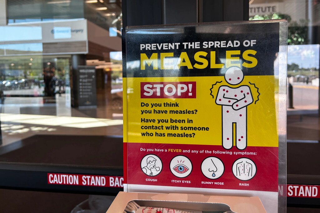 (Arielle Zionts | KFF Health News) A sign at a hospital in Rapid City, South Dakota, describes measles symptoms.