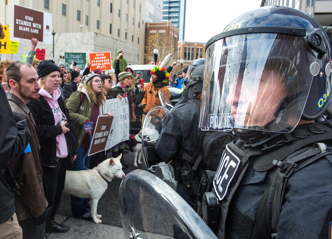 (Rick Egan  |  The Salt Lake Tribune)  Riot Police have a face-off with Protesters, as they block traffic on State Street, during President Trump's visit to Salt Lake CIty, Monday, December 4, 2017.