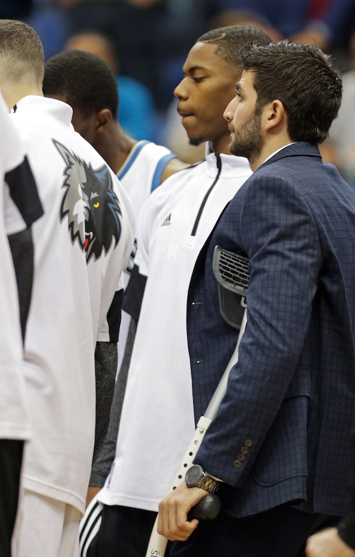 Minnesota Timberwolves' Ricky Rubio, right, of Spain, joins teammates while on crutches prior to an NBA basketball game against the New York Knicks, Wednesday, Nov. 19, 2014, in Minneapolis. Rubio is recovering form a high ankle sprain. (AP Photo/Jim Mone)