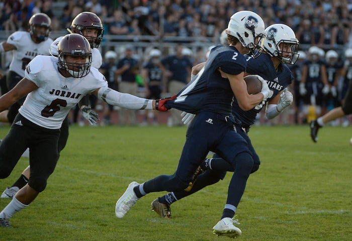 (Francisco Kjolseth  |  The Salt Lake Tribune)  Jordan's Anaia Tulaga grabs on to the shirt of Kaden Mueller of Syracuse in game action at Syracuse on Thursday, Aug. 24, 2017.