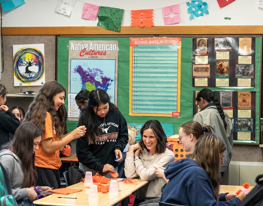 (Leah Hogsten | The Salt Lake Tribune) North Layton Junior High School Latinos in Action students from left, Amariah Avendano, Elaine Fuller and Ava Williams share a laugh with Vanessa Alder, the regional program manager for Latinos in Action while cutting paper circles, Oct. 6, 2022, while making marigold flowers for the school's Dia De Los Muertos Celebration on November 2nd.