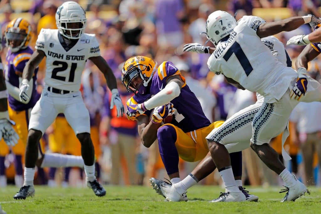 LSU wide receiver Ja'Marr Chase (1) pulls in a pass between Utah State cornerback DJ Williams (7) and cornerback Andre Grayson (21) in the first half of an NCAA college football game in Baton Rouge, La., Saturday, Oct. 5, 2019. (AP Photo/Gerald Herbert)