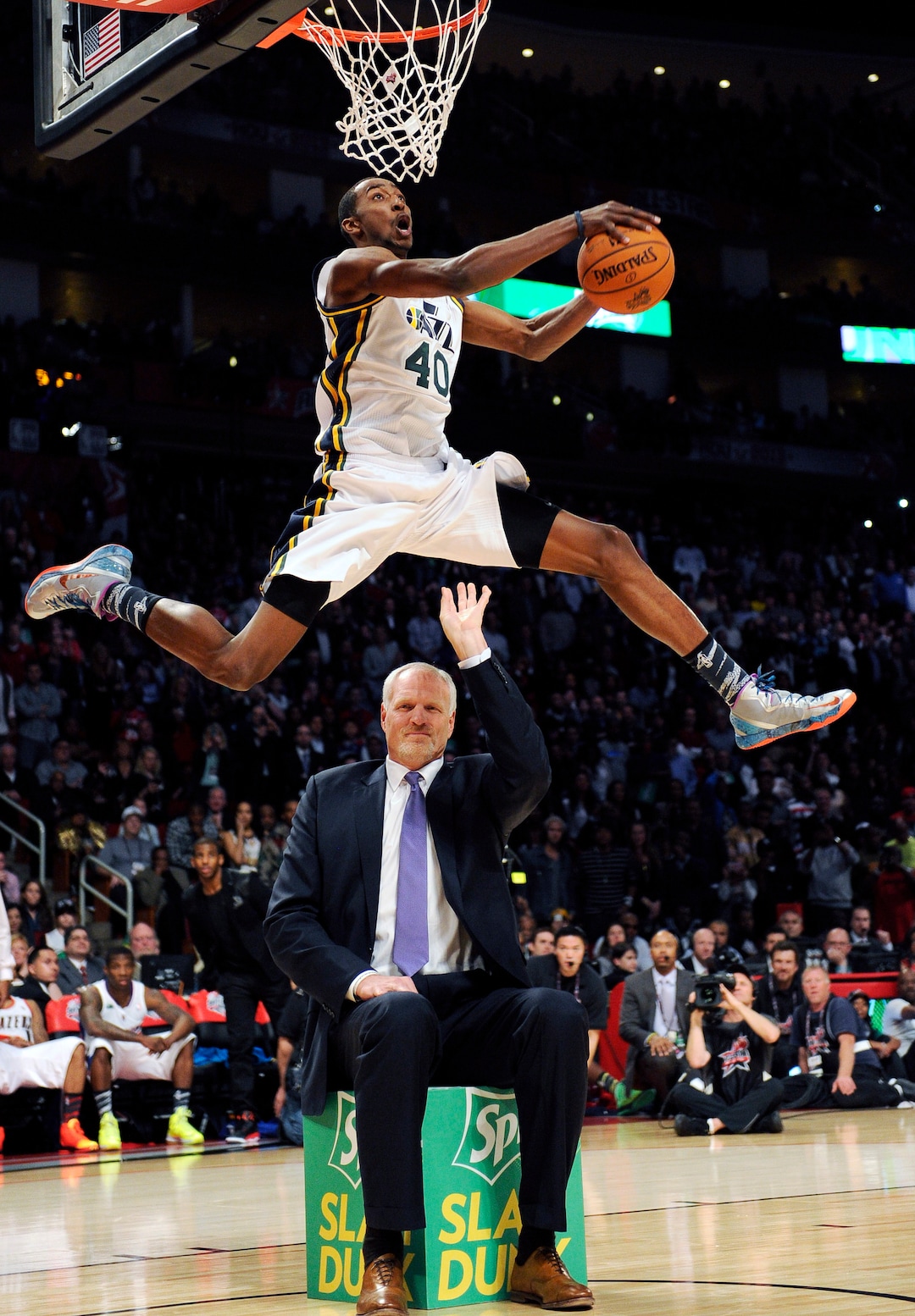 Former Utah Jazz center Mark Eaton hands the ball to Jazz's Jeremy Evans during the dunk contest at NBA basketball All-Star Saturday Night, Feb. 16, 2013, in Houston. (AP Photo/Pat Sullivan)