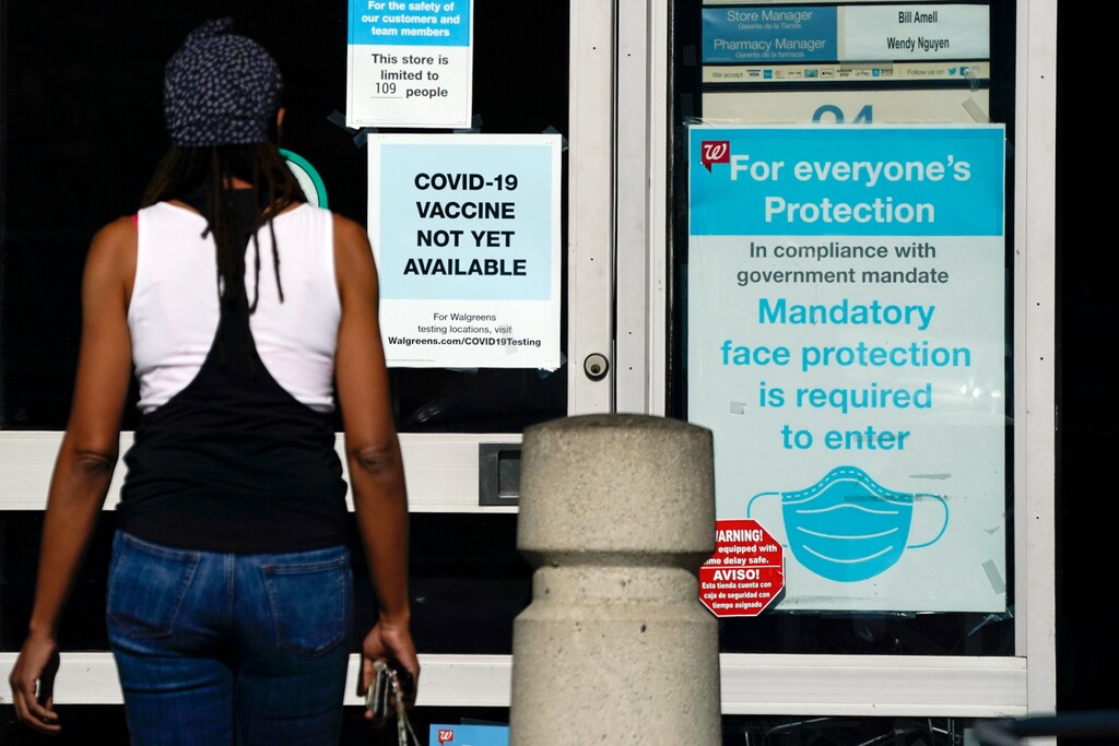 (Ashley Landis | AP file photo)  A customer walks past a sign indicating that a COVID-19 vaccine is not yet available at Walgreens in Long Beach, Calif., on Dec. 2, 2020.