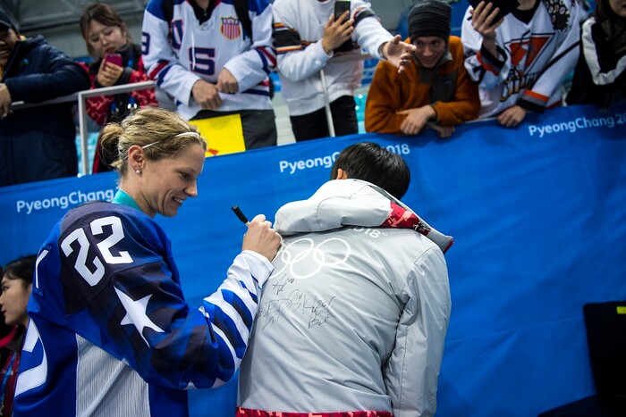 (Chris Detrick  |  The Salt Lake Tribune) United States defenseman Kacey Bellamy (22) signs her autograph on Han Sol Lee's jacket after winning the Women's Gold Medal Game at Gangneung Hockey Centre during the Pyeongchang 2018 Winter Olympics Thursday, Feb. 22, 2018. United States defeated Canada 3-2 in a shootout victory. 
