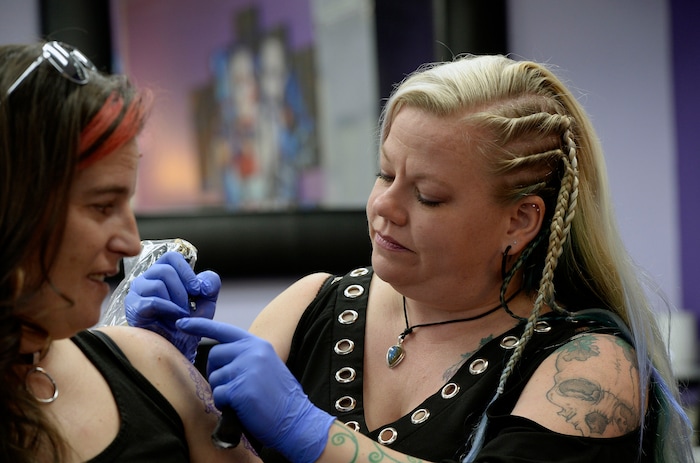 (Al Hartmann  |  The Salt Lake Tribune) 	
Terrina Francis, tatoo artist and owner of Fallen Angel Tattoo, is Salt Lake's only all-women tattoo studio.  She works on a personal tattoo for Shannon Gibbs.   The design is an old-fashioned cameo skull that she has thought about and wanted for four years.   Francis also offers to tattoo over scars and disfigurements due to domestic violence, breast cancer, and burns.   The shop offers a place where women can feel comfortable about getting tattooed in a very male-dominated field. 