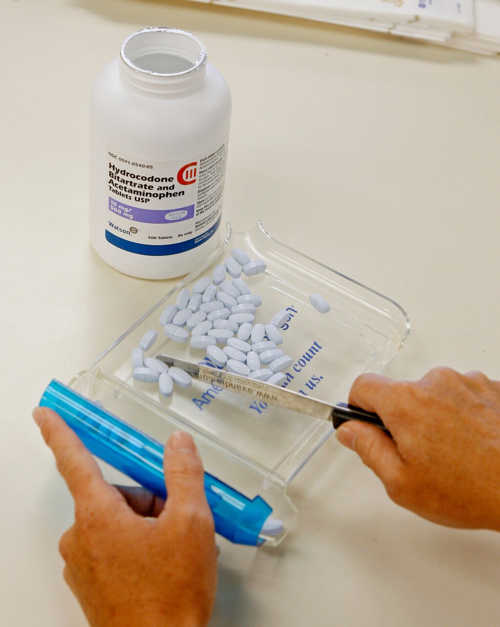 In this Aug. 5, 2010 file photo, a pharmacy technician poses for a picture with hydrocodone and acetaminophen tablets, also known as Vicodin, at the Oklahoma Hospital Discount Pharmacy in Edmond, Okla.  (AP Photo/Sue Ogrocki, File)