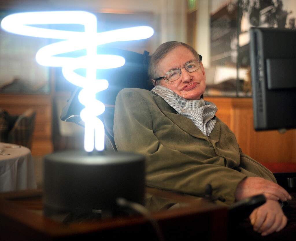 In this Feb. 25, 2012, photo, Professor Stephen Hawking poses beside a lamp titled "black hole light" by inventor Mark Champkins, presented to him during his visit to the Science Museum in London. Hawking, whose brilliant mind ranged across time and space though his body was paralyzed by disease, died early Wednesday, March 18, 2018, a University of Cambridge spokesman said. He was 76.
 (Anthony Devlin/PA via AP)