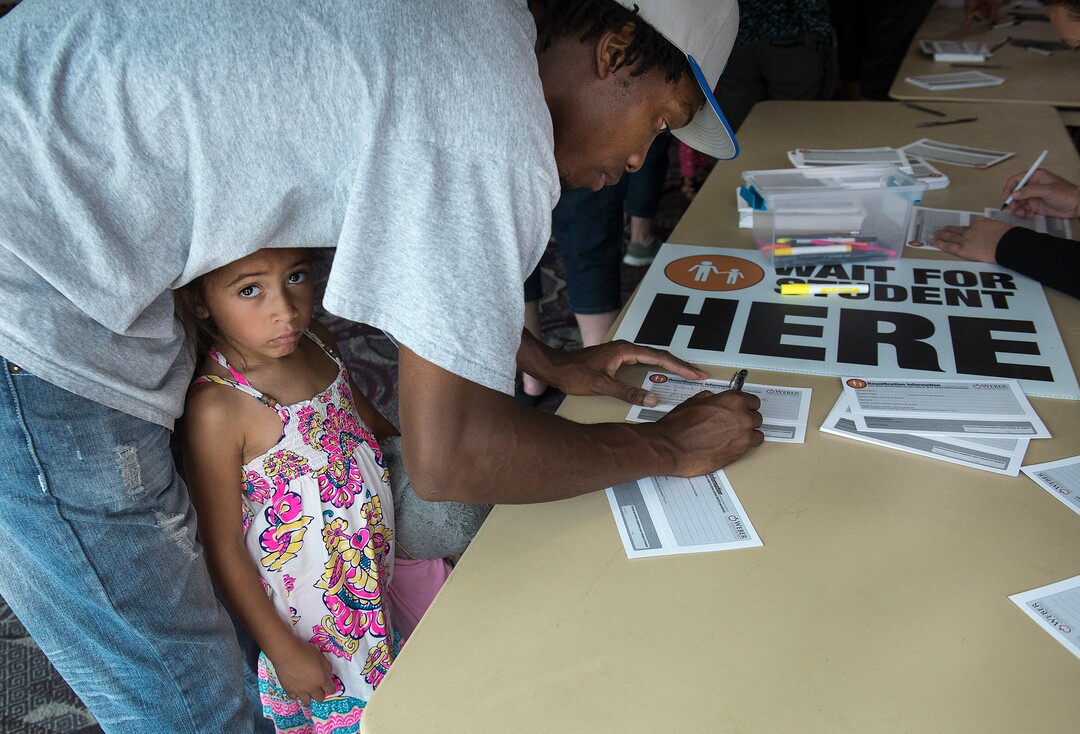 (Leah Hogsten  |  The Salt Lake Tribune) Liliana Dasni waits as her father Charles Dasni fills out a reunification form to be able to pick up his other two children who are students at Uintah Elementary School at the Dee Events Center on the Weber State University campus in Ogden. Evacuees were given food and water as residents waited to hear if they could return to their homes. The Uintah Fire is still burning through the town of Uintah and pockets of South Weber, as well as the unincorporated subdivision of Uintah Highlands.