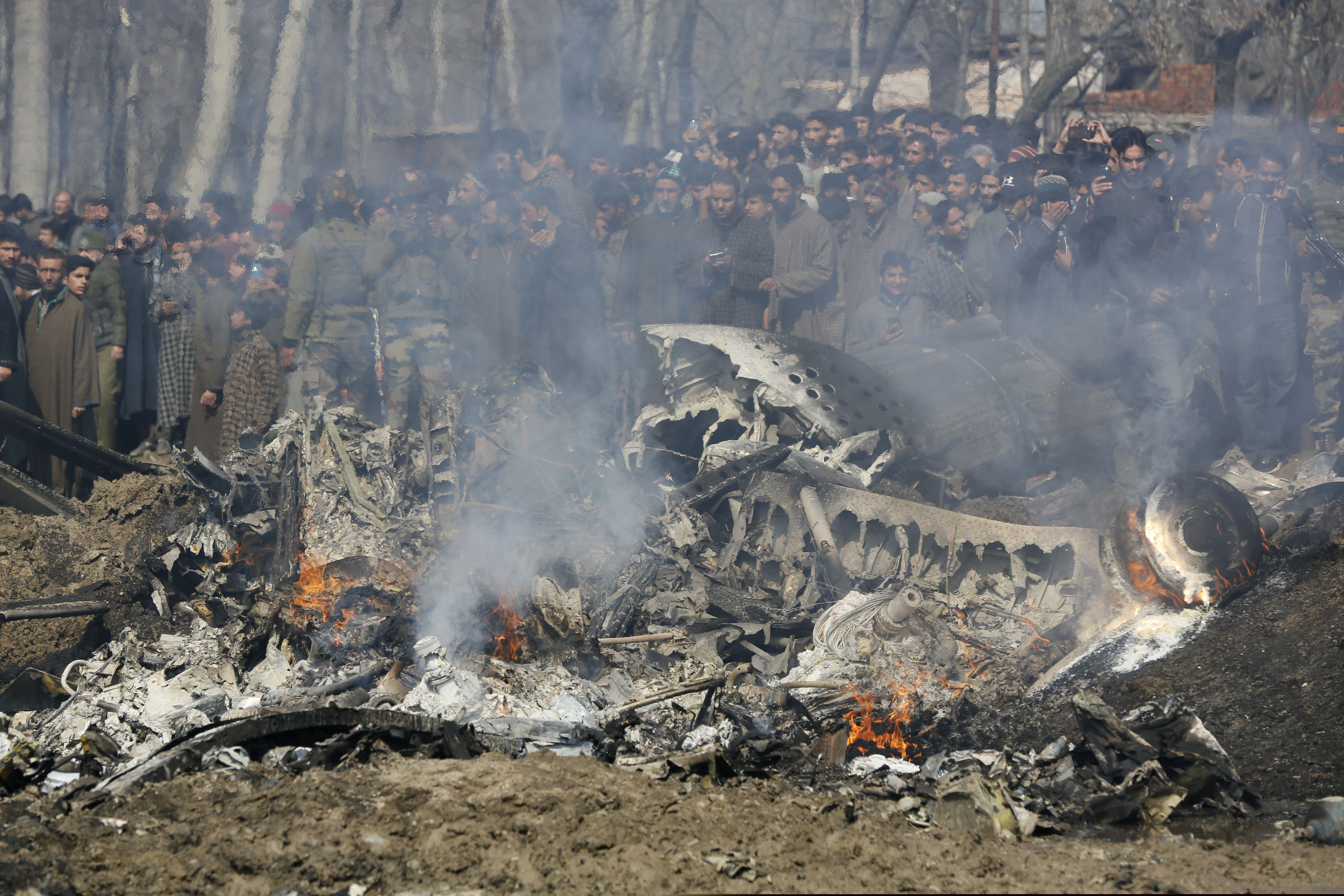 (Mukhtar Khan | The Associated Press) Kashmiri villagers gather near the wreckage of an Indian helicopter after it crashed in Budgam area, outskirts of Srinagar, Indian controlled Kashmir, Wednesday, Feb.27, 2019. The crash killed six Indian air force officials and a civilian on the ground.