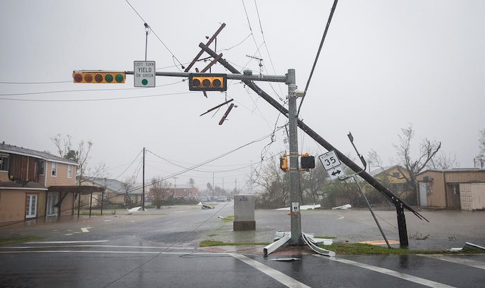 (Nick Wagner | Austin American-Statesman via AP) A snapped power pole leans against a stoplight after Hurricane Harvey ripped through Rockport, Texas, on Saturday, Aug. 26, 2017.  The fiercest hurricane to hit the U.S. in more than a decade spun across hundreds of miles of coastline where communities had prepared for life-threatening storm surges — walls of water rushing inland.