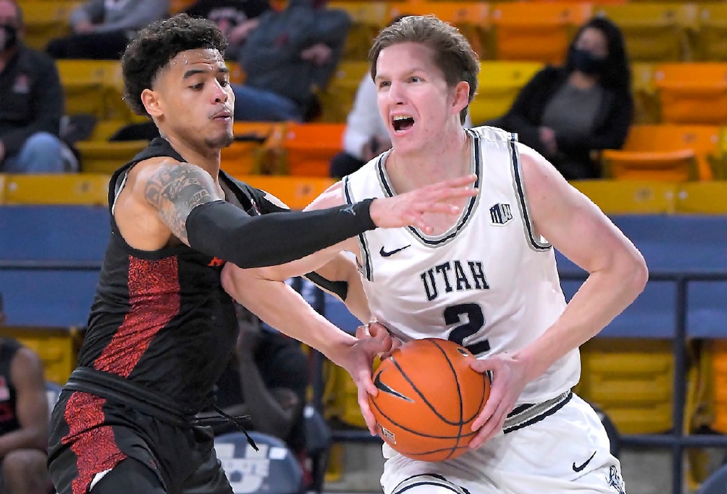 Utah State guard Sean Bairstow (2) drives to the basket as San Diego State guard Trey Pulliam defends during the first half of an NCAA college basketball game Thursday, Jan. 14, 2021, in Logan, Utah. (Eli Lucero/The Herald Journal via AP, Pool)
