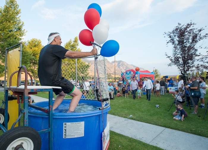 (Rick Egan  |  The Salt Lake Tribune)  Danny Ainge taunts the people throwing balls at the target, as he sits in a dunking booth, during a fundraiser in Provo for Tanner Ainge, who is running for congress, in Utah’s third district. Monday, August 7, 2017.