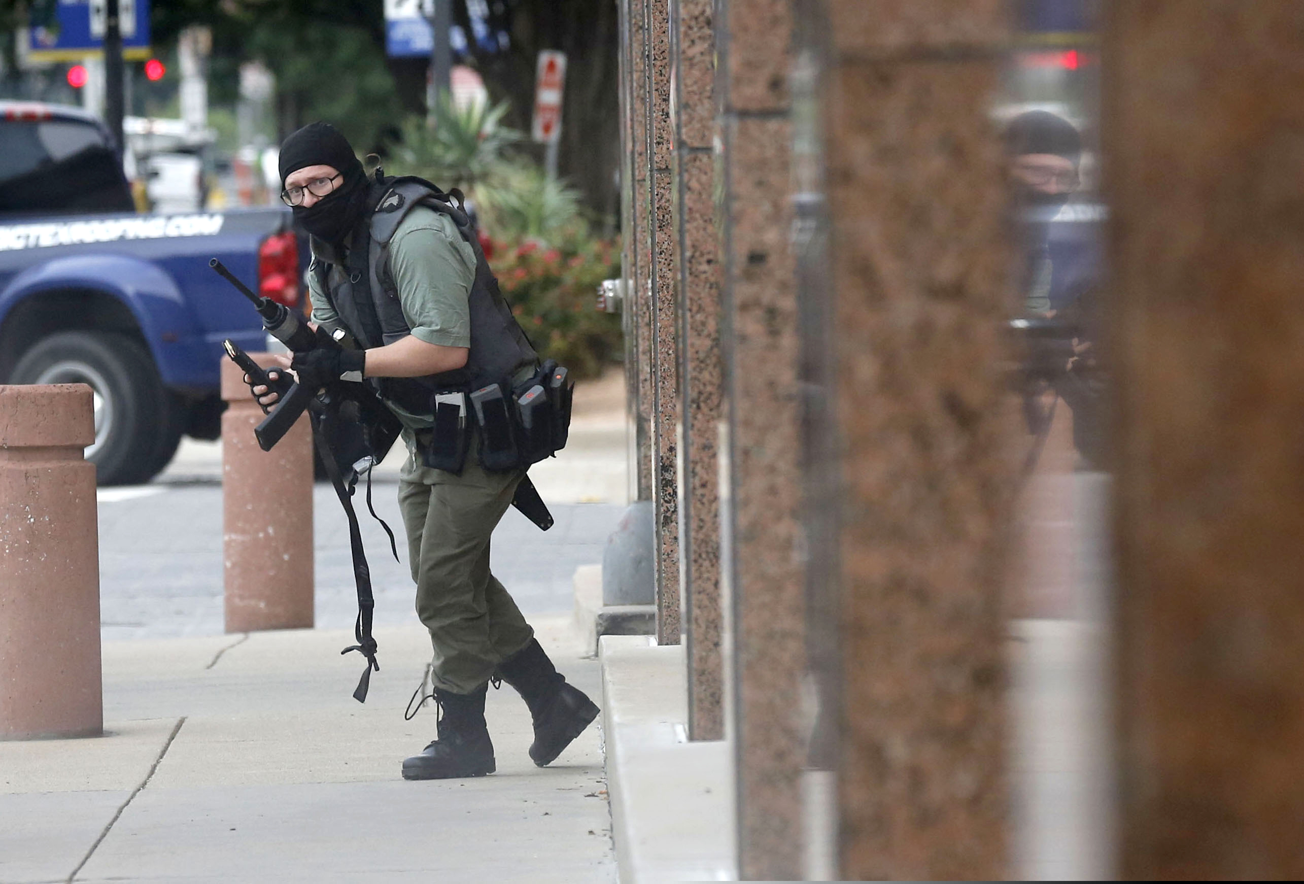 (Tom Fox | The Dallas Morning News via AP) An armed shooter stands near the Earle Cabell Federal Building Monday, June 17, 2019, in downtown Dallas. The shooter was hit and injured in an exchange of gunfire with federal officers outside the courthouse.