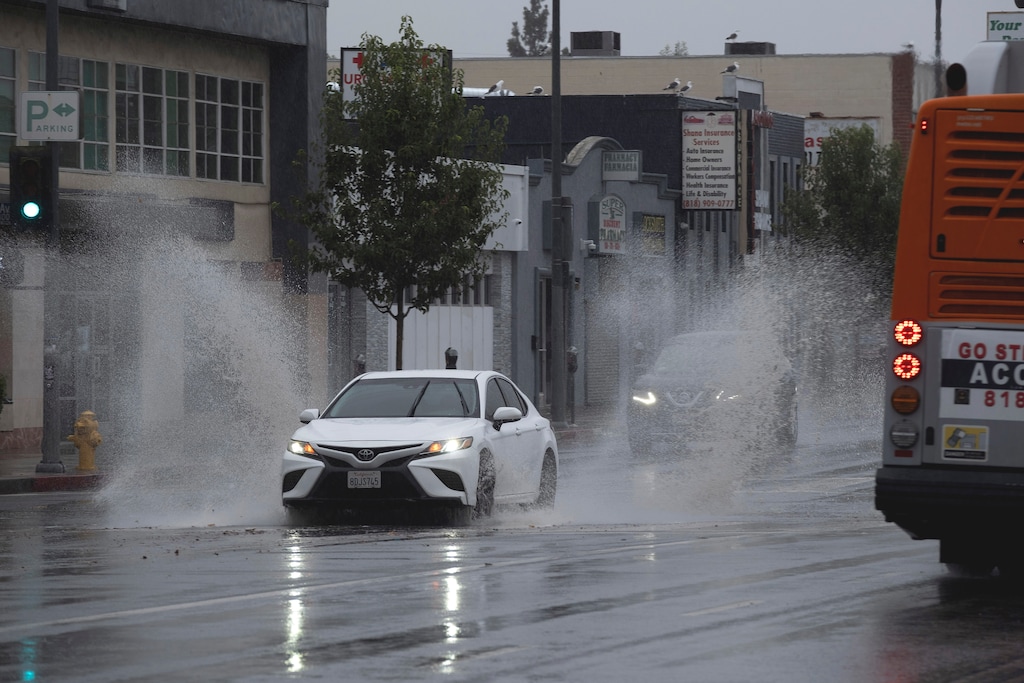 (Richard Vogel | The Associated Press) A vehicle splashes through puddles along a street starting to flood in the Van Nuys section of Los Angeles as a tropical storm moves into the area on Sunday, Aug. 20, 2023. Tropical Storm Hilary is no longer a hurricane but it's still packing what forecasters call "life-threatening" rain as it speeds up Mexico's Baja coast toward Southern California.