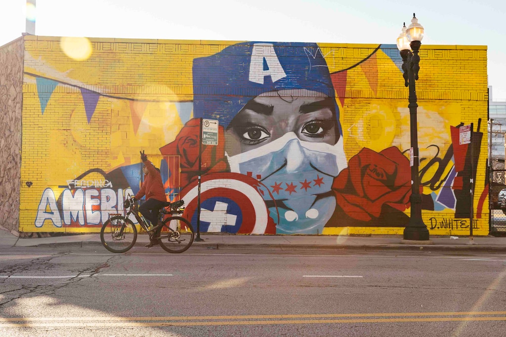 (Taylor Glascock | The New York Times)
A cyclist rides past a mural in Chicago on Dec. 21, 2021. "The persistence of COVID-19 has helped keep the nation’s mood dark, which inevitably hurts the party that holds the White House — so Republicans who have done all they can to prevent an effective response to Covid have not hesitated, even for a moment, in blaming Biden for failing to end the pandemic," writes The New York Times columnist Paul Krugman.
