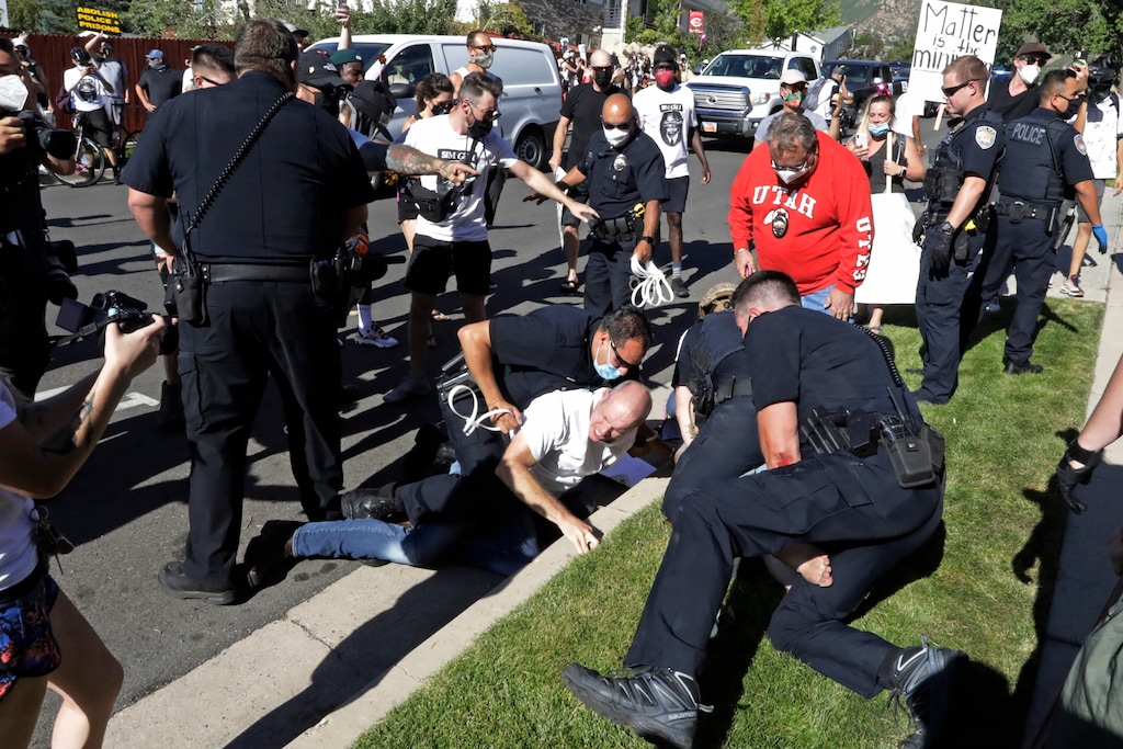 Aaron James is arrested by Cottonwood Heights Police during a march Sunday, Aug. 2, 2020, in Cottonwood Heights, Utah. James was among eight people arrested by Cottonwood Heights Police. He is the father Zane James, a 19-year-old white man who was shot and killed by a Cottonwood Heights Police officer in 2018 as he fled the scene of a robbery. His parents, Tiffany and Aaron James, alleged in a lawsuit filed against the police department last year that their son didn't pose a threat and shouldn't have been shot. (AP Photo/Rick Bowmer)