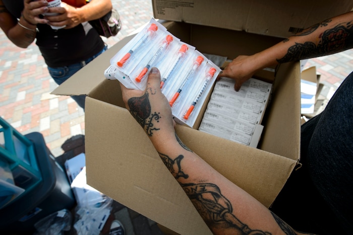 (Steve Griffin  |  The Salt Lake Tribune)  Volunteer Crystal Yazzie helps members from the Utah Harm Reduction Coalition as they exchange needles on 500 West between 200 South and 300 South in Salt Lake City, Thursday July 27, 2017. The state's increased attention to the Rio Grande neighborhood comes as Utah's leading needle-exchange provider is under fire for handing out more needles than it collects. Mindy Vincent, founder of the coalition, says the goal was never to break even, and that optics aside, needle exchange is proven to reduce the spread of disease among IV drug users.