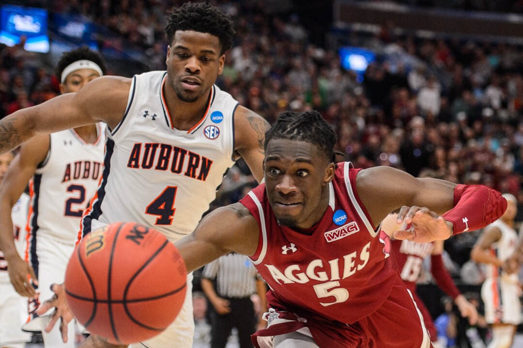(Trent Nelson | The Salt Lake Tribune)  New Mexico State Aggies guard Clayton Henry (5) dives after a loose ball as Auburn faces New Mexico State in the 2019 NCAA Tournament in Salt Lake City on Thursday March 21, 2019. At left is Auburn Tigers guard Malik Dunbar (4).