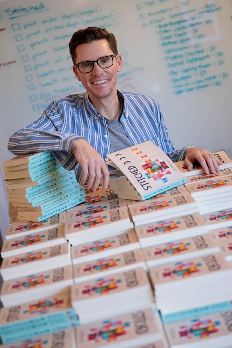 (Francisco Kjolseth | The Salt Lake Tribune) Salt Lake Tribune humor columnist Eli McCann, signs copies of his new book called "Stitched" with Torrey House Press on Wednesday, Aug. 19, 2026.