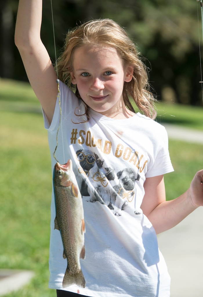 (Rick Egan  |  The Salt Lake Tribune)        Mira Peterson 11, shows off the fish she caught at Fairmont Park Pond, during the grand reopening celebration, Wednesday, June 27, 2018.