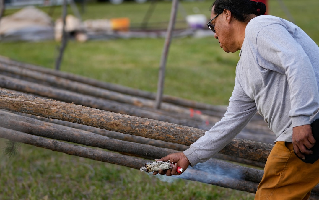 (Francisco Kjolseth | The Salt Lake Tribune) Ute dance chairman Paul Larose uses burning sage to bless timbers that will be used to erect several tepees as part of a multi-day Bear Dance on the Reservation community of Whiterocks in eastern Utah for the first time in 20 years on Thursday, May 19, 2022.