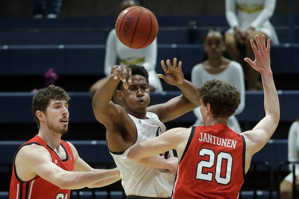 California forward D.J. Thorpe, middle, passes the ball while being defended by Utah forward Riley Battin, left, and forward Mikael Jantunen (20) during the first half of an NCAA college basketball game in Berkeley, Calif., Saturday, Feb. 29, 2020. (AP Photo/Jeff Chiu)