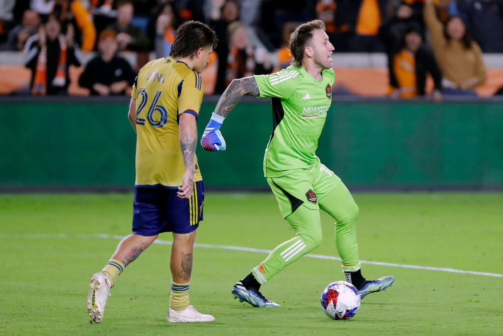 Houston Dynamo goalkeeper Steve Clark, right, celebrates after blocking a kick by Real Salt Lake midfielder Diego Luna (26) in the overtime penalty shootout during the second half of an MLS playoff soccer match Saturday, Nov. 11, 2023, in Houston. (AP Photo/Michael Wyke)