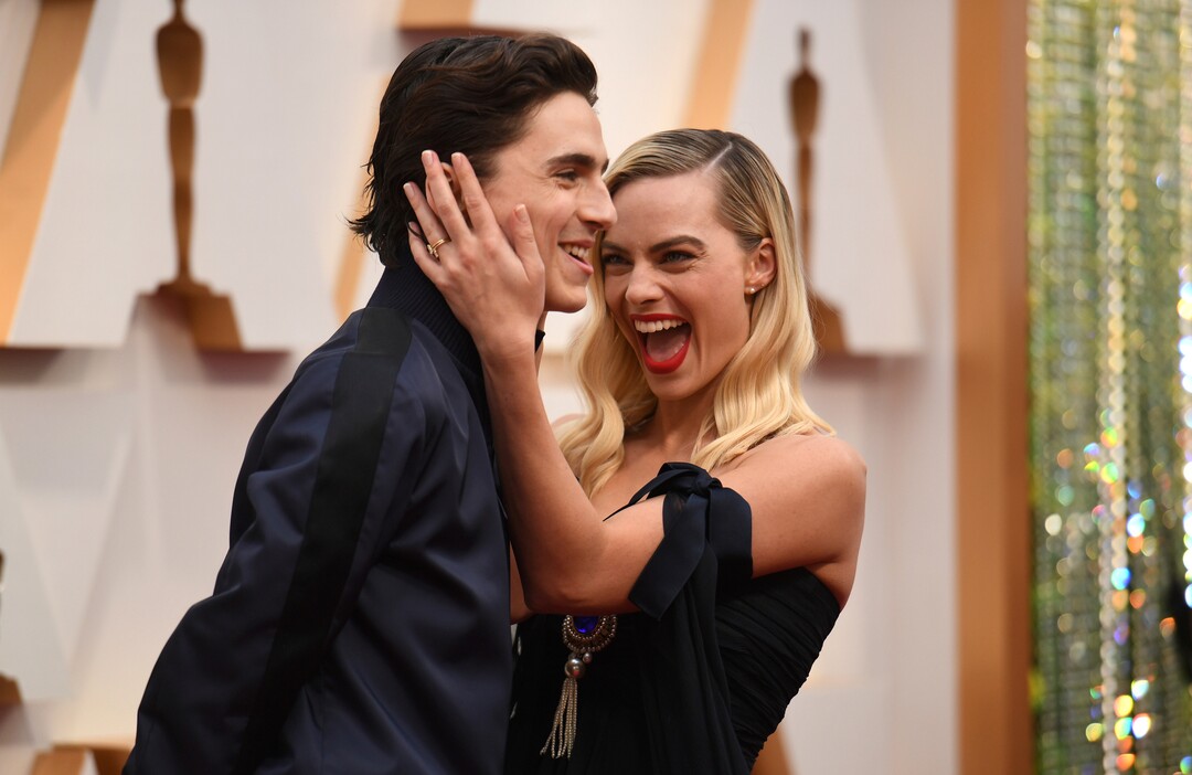 (Richard Shotwell | Invision/AP)  Timothee Chalamet, left, and Margot Robbie arrive at the Oscars on Sunday, Feb. 9, 2020, at the Dolby Theatre in Los Angeles.