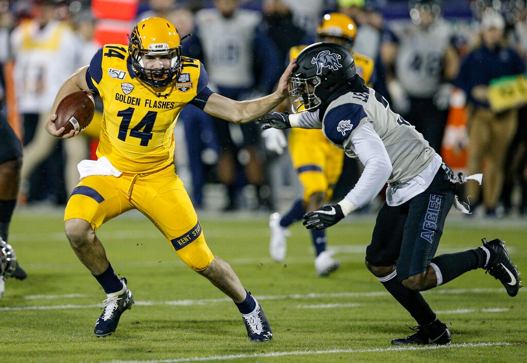 Kent State quarterback Dustin Crum (14) carries the ball as Utah State safety Troy Lefeged Jr. (3) defends during the first half of the Frisco Bowl NCAA college football game Friday, Dec. 20, 2019, in Frisco, Texas. (AP Photo/Brandon Wade)